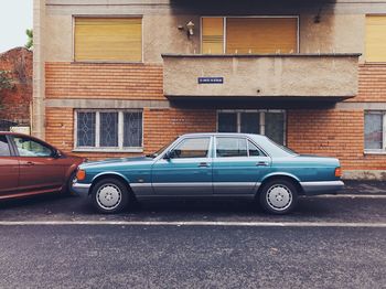 Cars parked on road by buildings in city