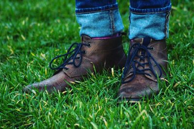 Low section of man standing on grassy field