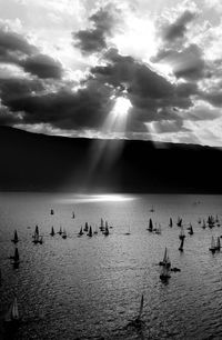 Silhouette boats in sea against sky