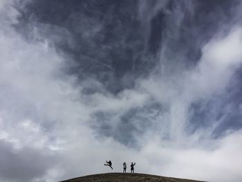 Distance shot of people jumping on landscape