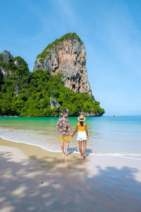 Rear view of woman standing at beach