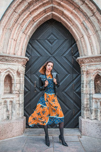 Portrait of woman standing against built structure