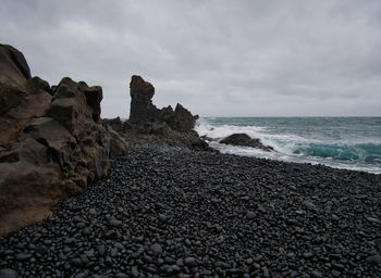 Rocks on beach against sky