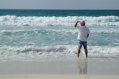 Rear view of man standing at beach