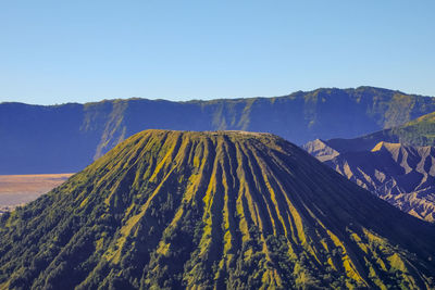 Panoramic view of volcanic mountain against blue sky