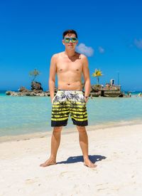 Portrait of shirtless man standing on beach