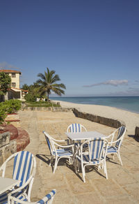 Chairs on beach against clear sky