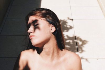 Portrait of beautiful young woman against wall