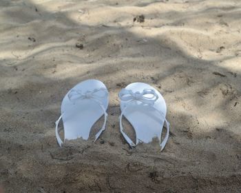 High angle view of white slippers at sandy beach