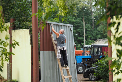 A man paints the iron fence of his house. high quality photo