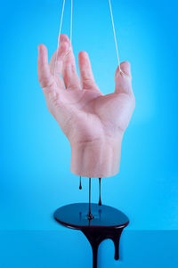 Midsection of person holding blue light against wall