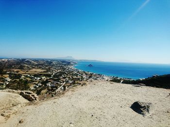 Scenic view of calm beach against clear blue sky