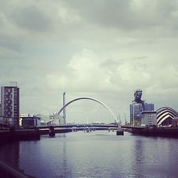 Bridge over river against cloudy sky