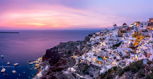 High angle view of townscape by sea against sky during sunset