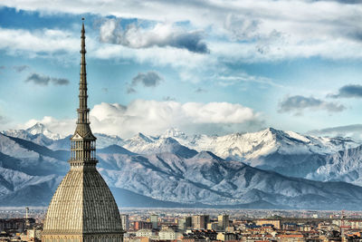 View of cityscape against cloudy sky