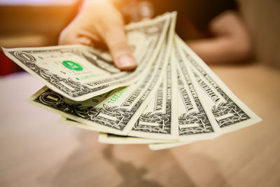 Close-up of woman holding dollar bills