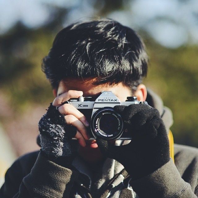 lifestyles, leisure activity, focus on foreground, holding, photography themes, casual clothing, childhood, photographing, technology, headshot, boys, camera - photographic equipment, elementary age, waist up, wireless technology, person, men, digital camera