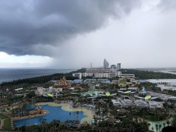 High angle view of city by sea against sky