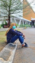 A woman sitting on footpath