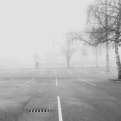 Empty road against sky during foggy weather
