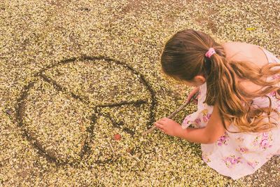 Girl drawing freedom sign on the ground