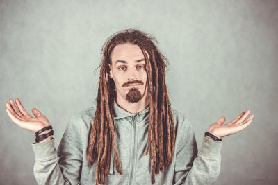 Portrait of young man standing against wall