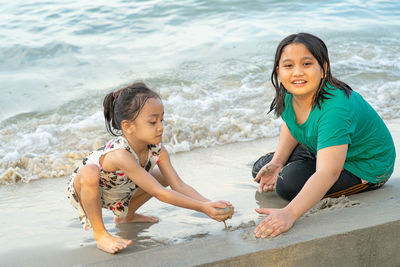 Children playing sand together. asian little kids playing at the beach.