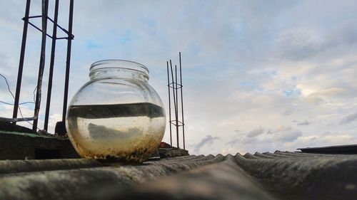 Fish bowl on roof against cloudy sky