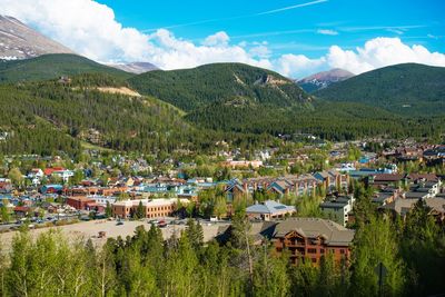 Scenic view of townscape and mountains against sky