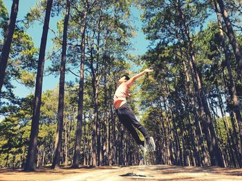 Full length of man jumping in forest