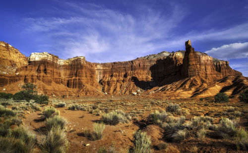 Rock formations on landscape against cloudy sky