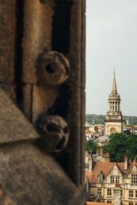 Church and buildings in city against sky