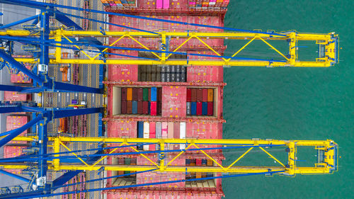 Directly above shot of crane and cargo container by lake