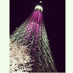 Low angle view of illuminated tower at night