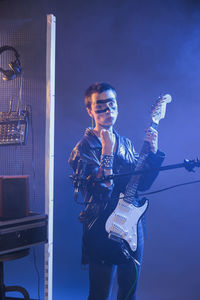 Portrait of young man playing guitar