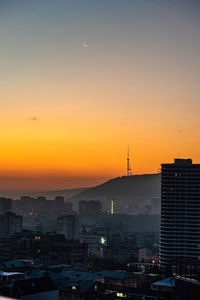 High angle view of silhouette buildings against sky during sunset