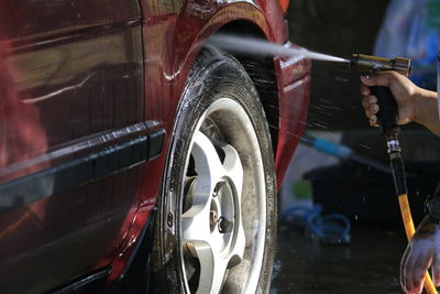 Cropped image of person washing car