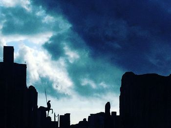 Low angle view of silhouette buildings against sky