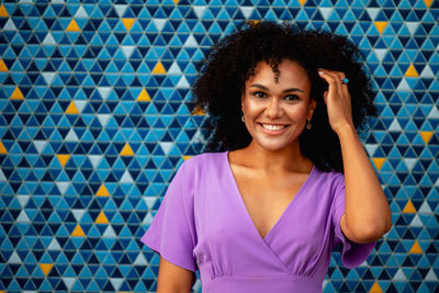 Portrait of smiling woman standing against tiled wall