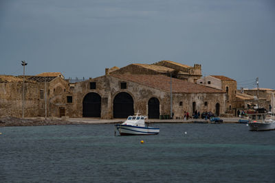 Boats in sea against buildings