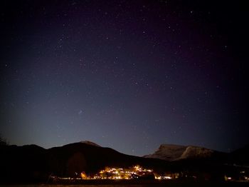 Scenic view of illuminated mountains against sky at night