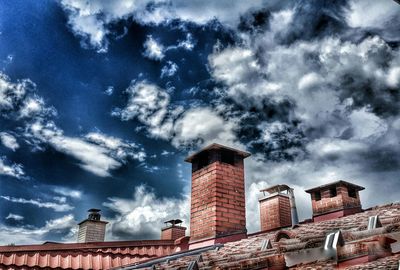 Low angle view of buildings against cloudy sky