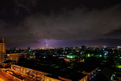 High angle view of illuminated cityscape against sky at night