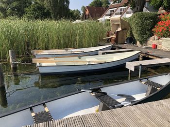 Boats moored by lake against trees