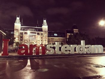 Text on illuminated building against sky at night