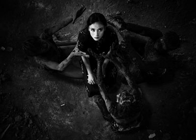High angle view of young woman sitting on field
