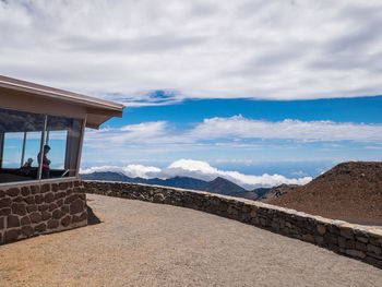 Scenic view of mountain range against cloudy sky