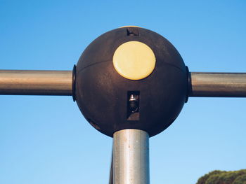 Low angle view of railing with lighting equipment against clear blue sky