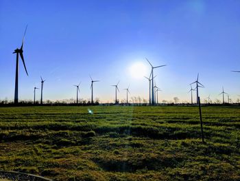 Windmills on field against sky