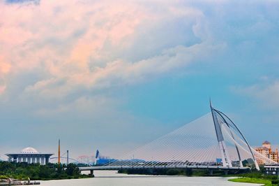 Suspension bridge against cloudy sky